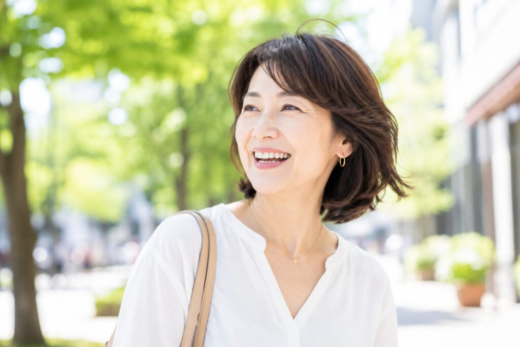 50代女性が外で楽しそうに笑っている２