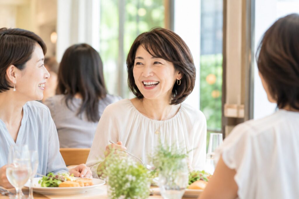 ランチ会に出席して楽しそうに笑っている50代女性